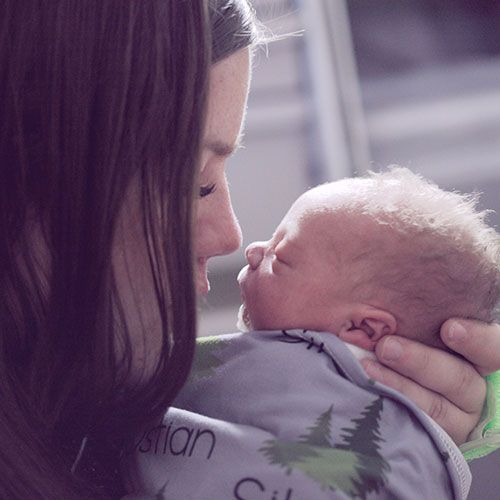 woman holding a newborn baby and touching nose to nose